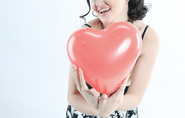 Bella giovane donna che tiene cuore rosso del pallone