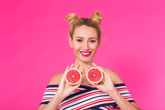 Bella giovane donna che tiene pezzo di arancia