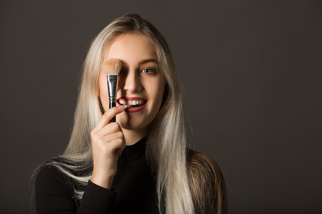 Bella giovane donna che usando il trucco