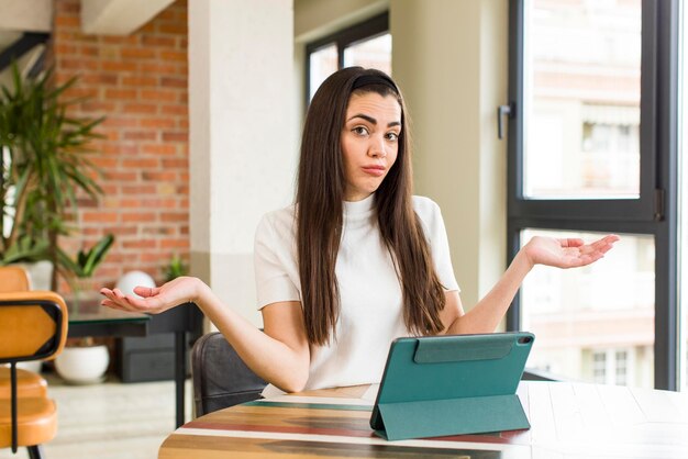 Bella giovane donna che utilizza un tablet touch screen a casa interior design della casa