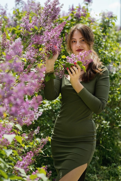 Bella giovane donna circondata da fiori lilla