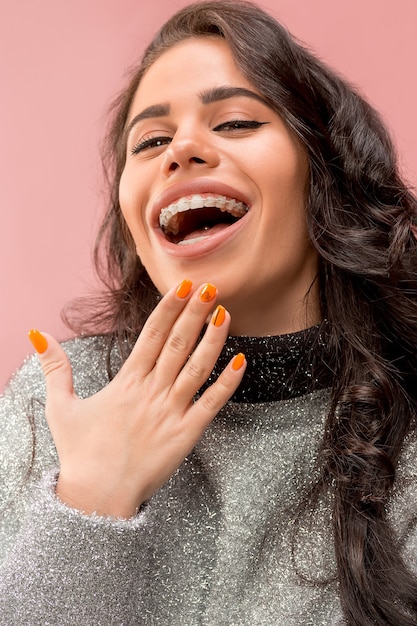 Bella giovane donna con bretelle per denti in rosa