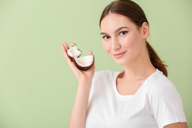 Bella giovane donna con cocco su green