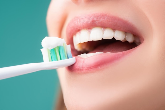Bella giovane donna con denti sani bella femmina sorriso closeup bocca con spazzolino da denti