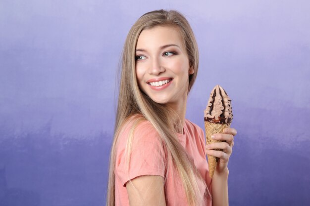 Bella giovane donna con gelato su viola