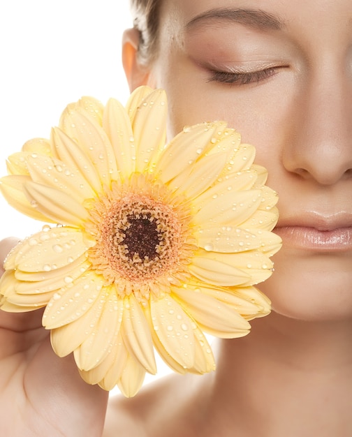 Bella giovane donna con gerber fiore isolato su sfondo bianco