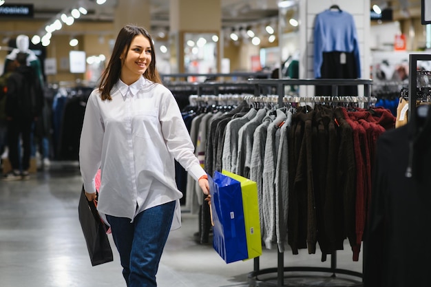 Bella giovane donna con le borse nel centro commerciale