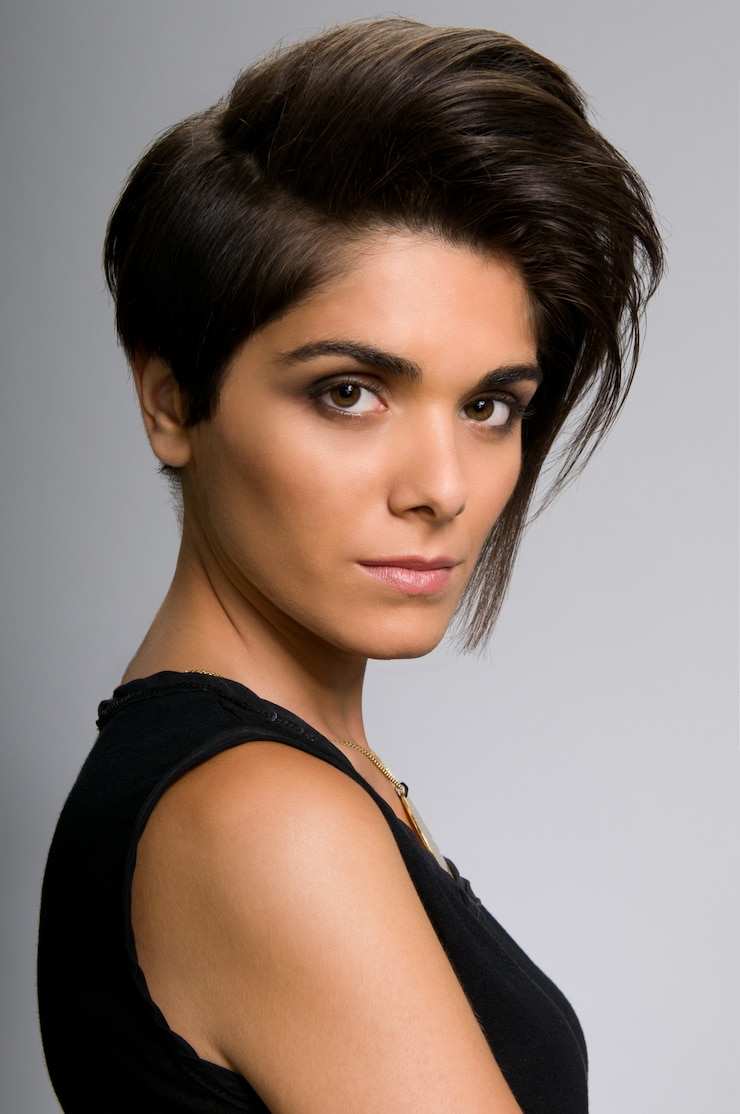 Foto bella giovane donna con taglio di capelli corto dritto sul muro grigio