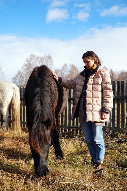 Bella giovane donna con un cavallo nel paese