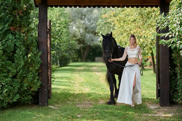 bella giovane donna con un cavallo nero