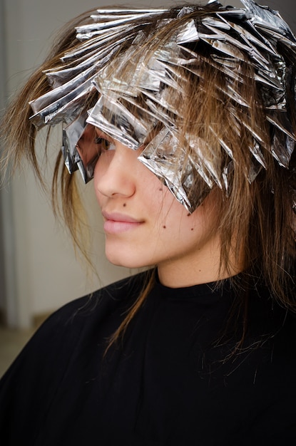 Bella giovane donna con un foglio sui suoi capelli