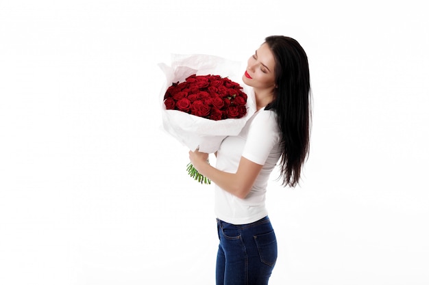 Bella giovane donna con un grande mazzo di rose rosse