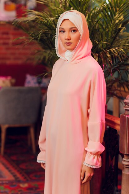 Bella giovane donna con un hijab rosa.