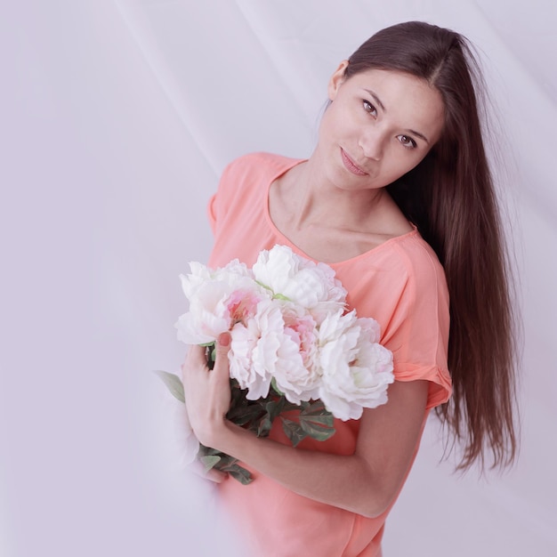 Bella giovane donna con un mazzo di peoniefoto con copia spazio