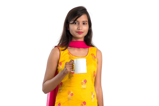 Bella giovane donna con una tazza di tè o caffè in posa