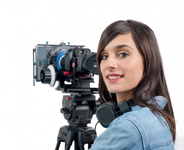 Bella giovane donna con videocamera DSLR e cuffie