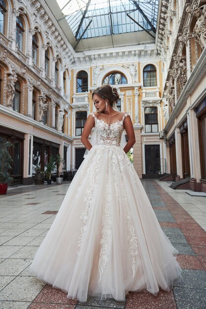 Bella giovane donna delicata, sposa in lussuoso abito da sposa