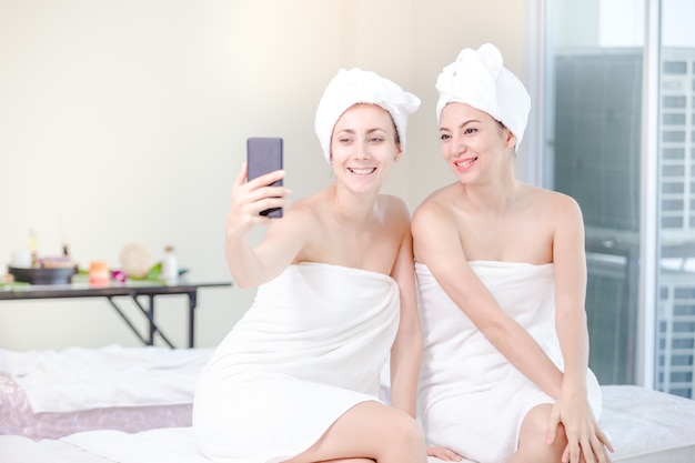 Bella giovane donna e amici rilassante spa salon con presa selfi presso spa resort