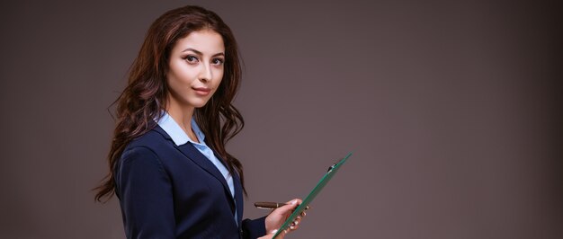 Bella giovane donna elegante di affari con una cartella nelle sue mani