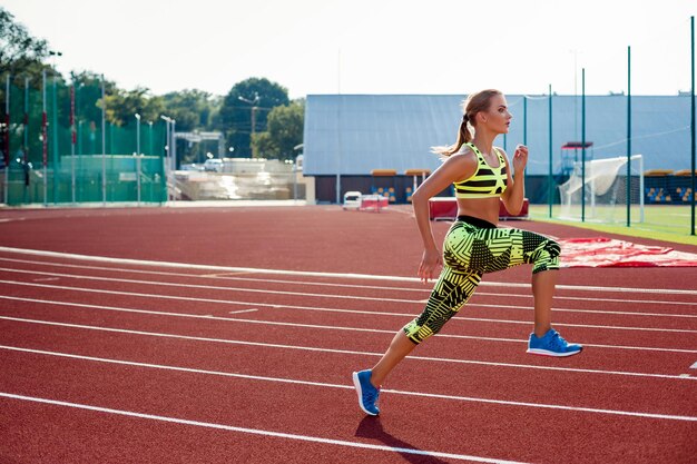 Bella giovane donna esercizio jogging e corsa su pista di atletica su stadium