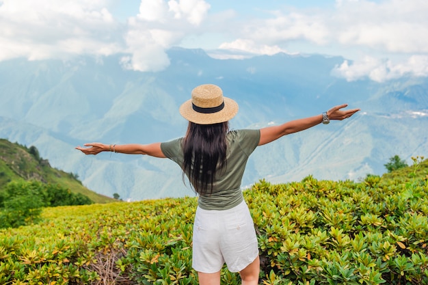 Bella giovane donna felice in montagna sullo sfondo della nebbia