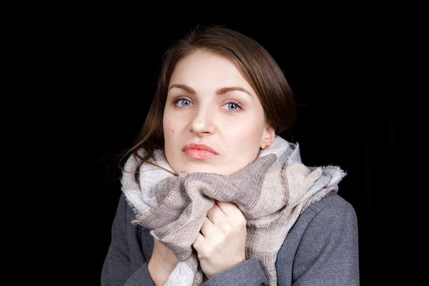 bella giovane donna ha avvolto il collo in una calda sciarpa di lana