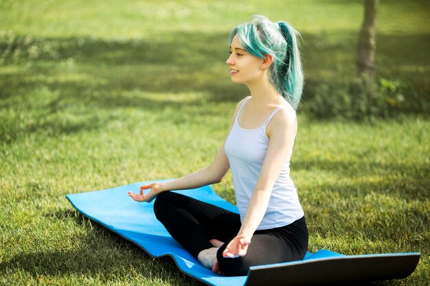 Bella giovane donna in abiti sportivi all'aperto nel parco