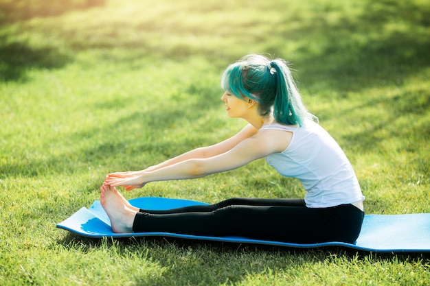 Bella giovane donna in abiti sportivi all'aperto nel parco