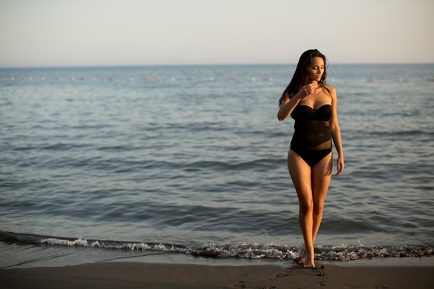 Bella giovane donna in bikini in spiaggia