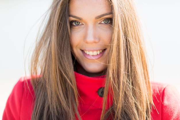 Bella giovane donna in cappotto rosso