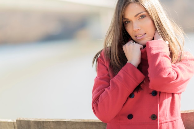 Bella giovane donna in cappotto rosso