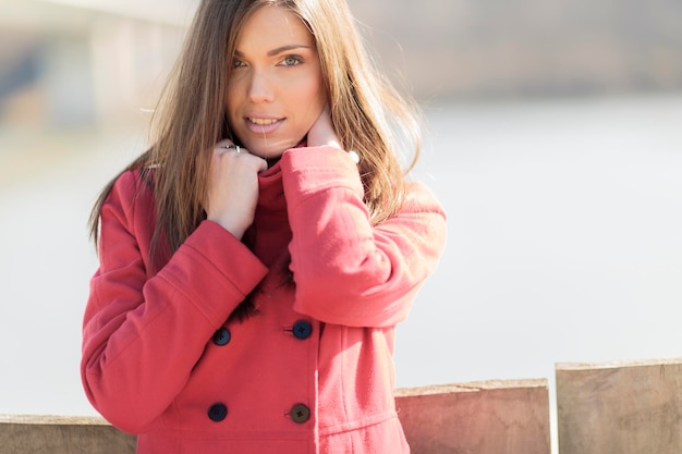 Bella giovane donna in cappotto rosso