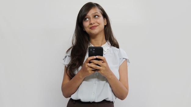 Bella giovane donna in chat da smartphone isolato su sfondo grigio