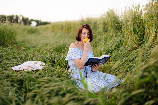 Bella giovane donna in estate in un campo di grano