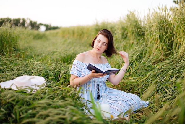 Bella giovane donna in estate in un campo di grano