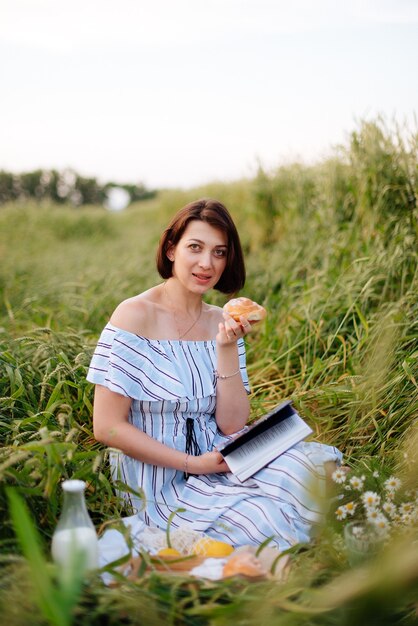 Bella giovane donna in estate in un campo di grano