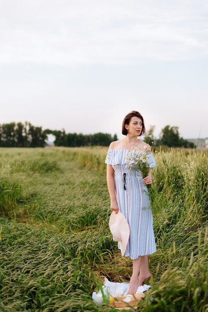 Bella giovane donna in estate in un campo di grano