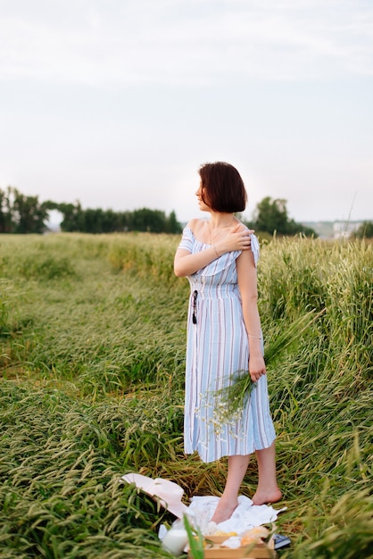 Bella giovane donna in estate in un campo di grano