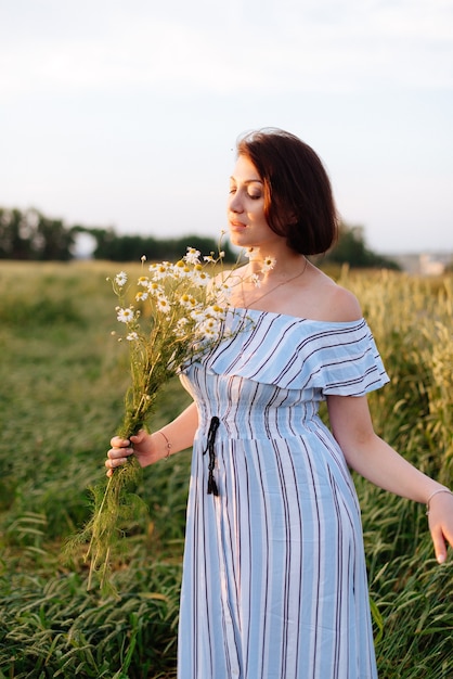 Bella giovane donna in estate in un campo di grano