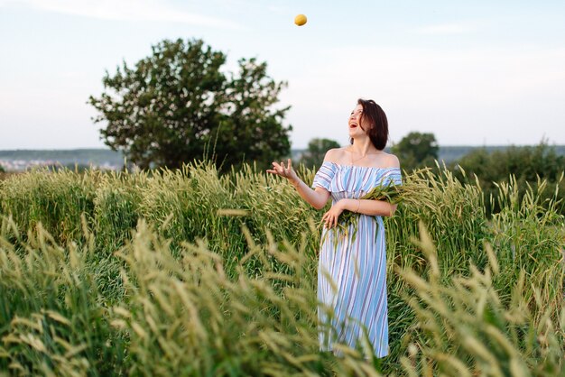 Bella giovane donna in estate in un campo di grano