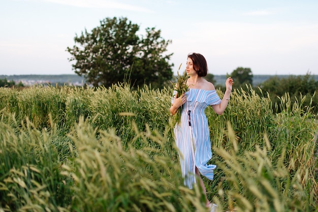 Bella giovane donna in estate in un campo di grano