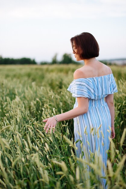 Bella giovane donna in estate in un campo di grano