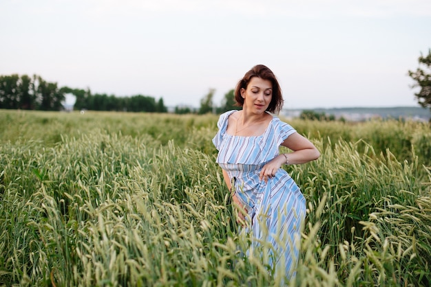 Bella giovane donna in estate in un campo di grano