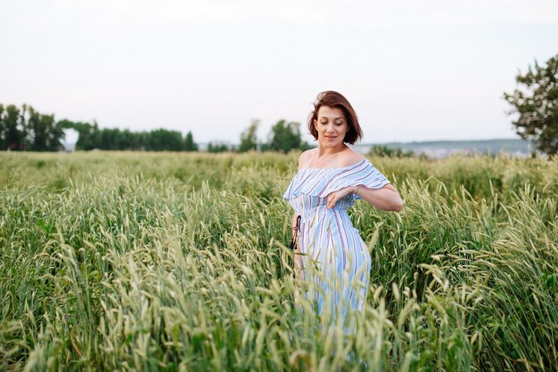 Bella giovane donna in estate in un campo di grano