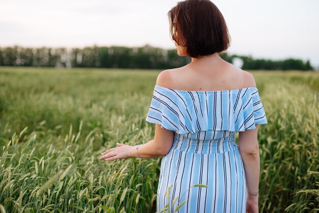 Bella giovane donna in estate in un campo di grano