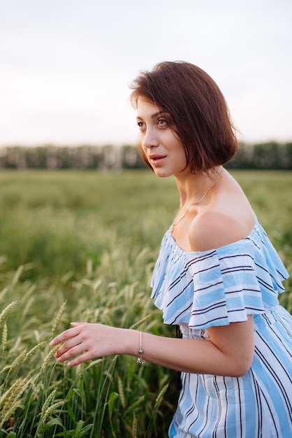 Bella giovane donna in estate in un campo di grano