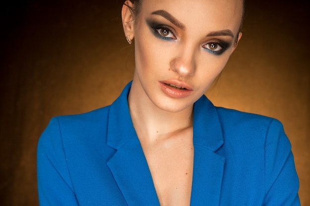 Bella giovane donna in giacca blu con trucco di bellezza