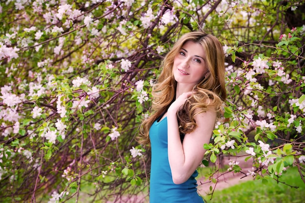 Bella giovane donna in giardino fiorito