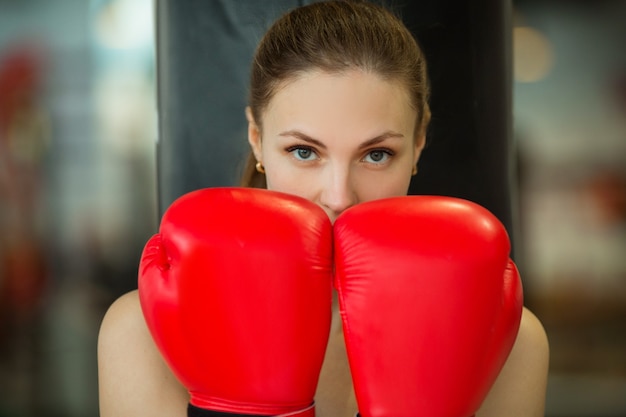 bella giovane donna in guantoni da boxe durante la formazione