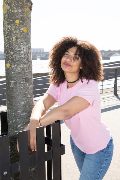 bella giovane donna in maglietta rosa con i capelli ricci